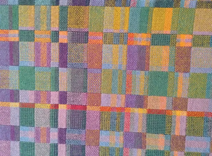 Artisan weaving a complex carpet pattern