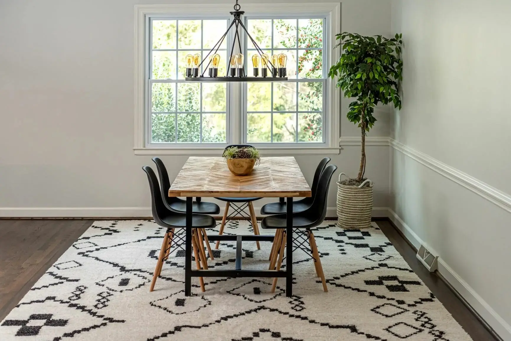 An elegant dining room where a durable, patterned rug sits under the table.